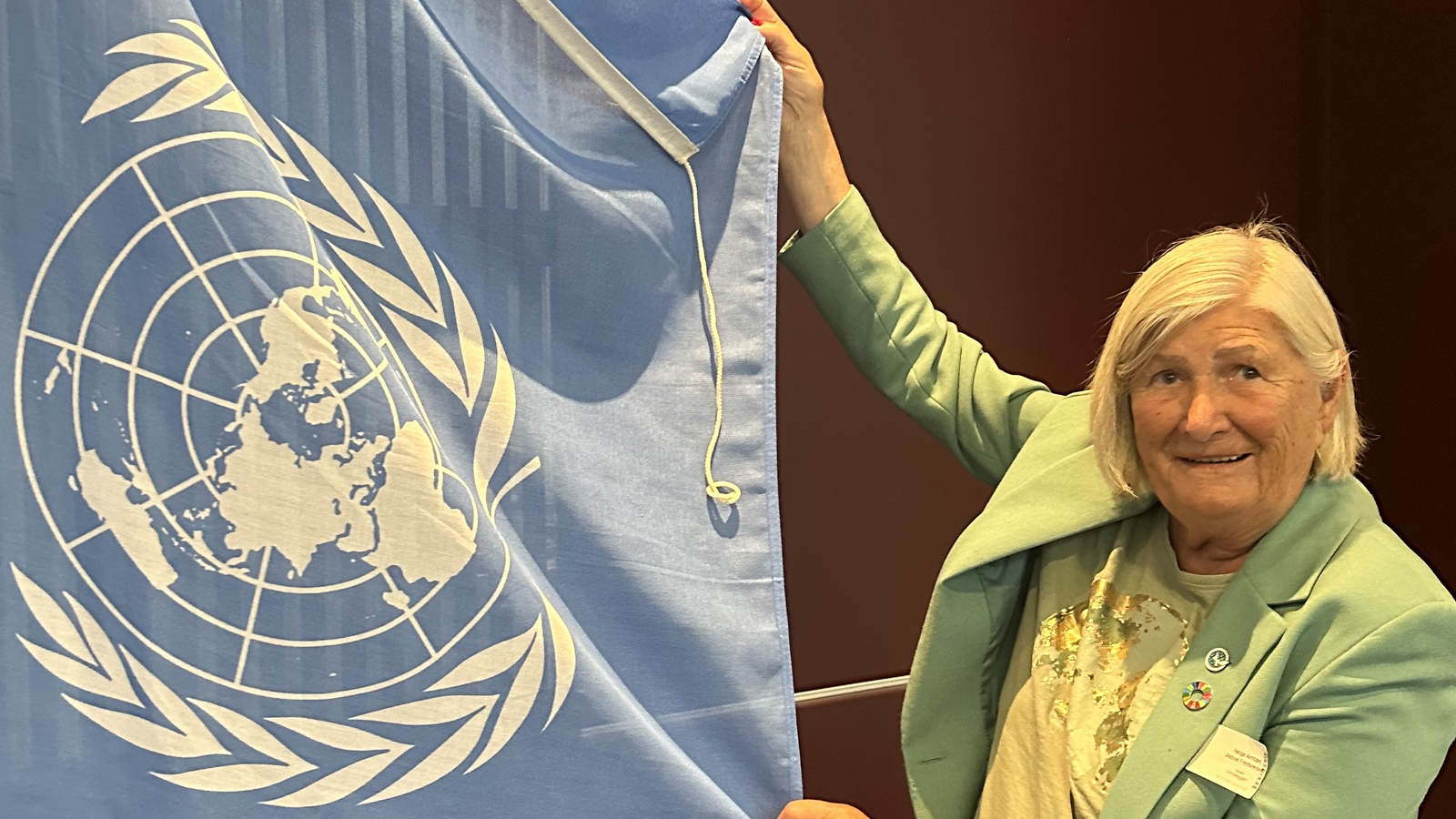 Helga fra Aktive Fredsreiser holder FN-flagget – markering av FN-dagen